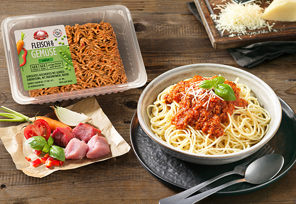 Hofstädter Fleisch & Gemüse in Verpackung und eine Portion Spaghetti Bolognese auf einem Holztisch