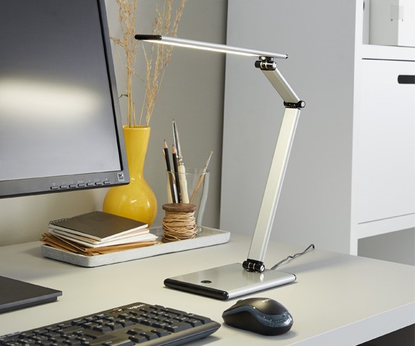 Schreibtischleuchte auf Schreibtisch neben Monitor